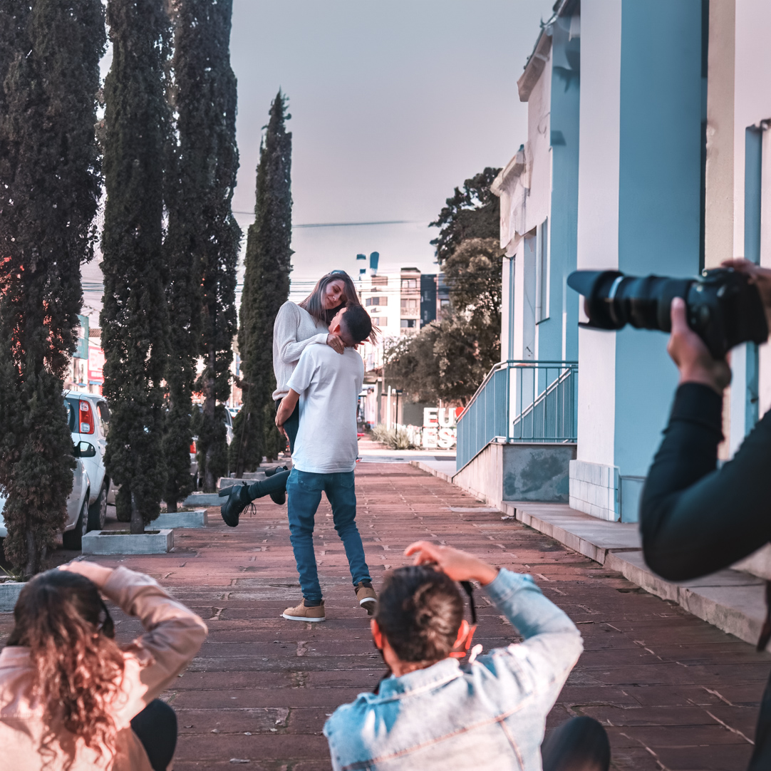 Alunos fotografando um casal em aula prática externa